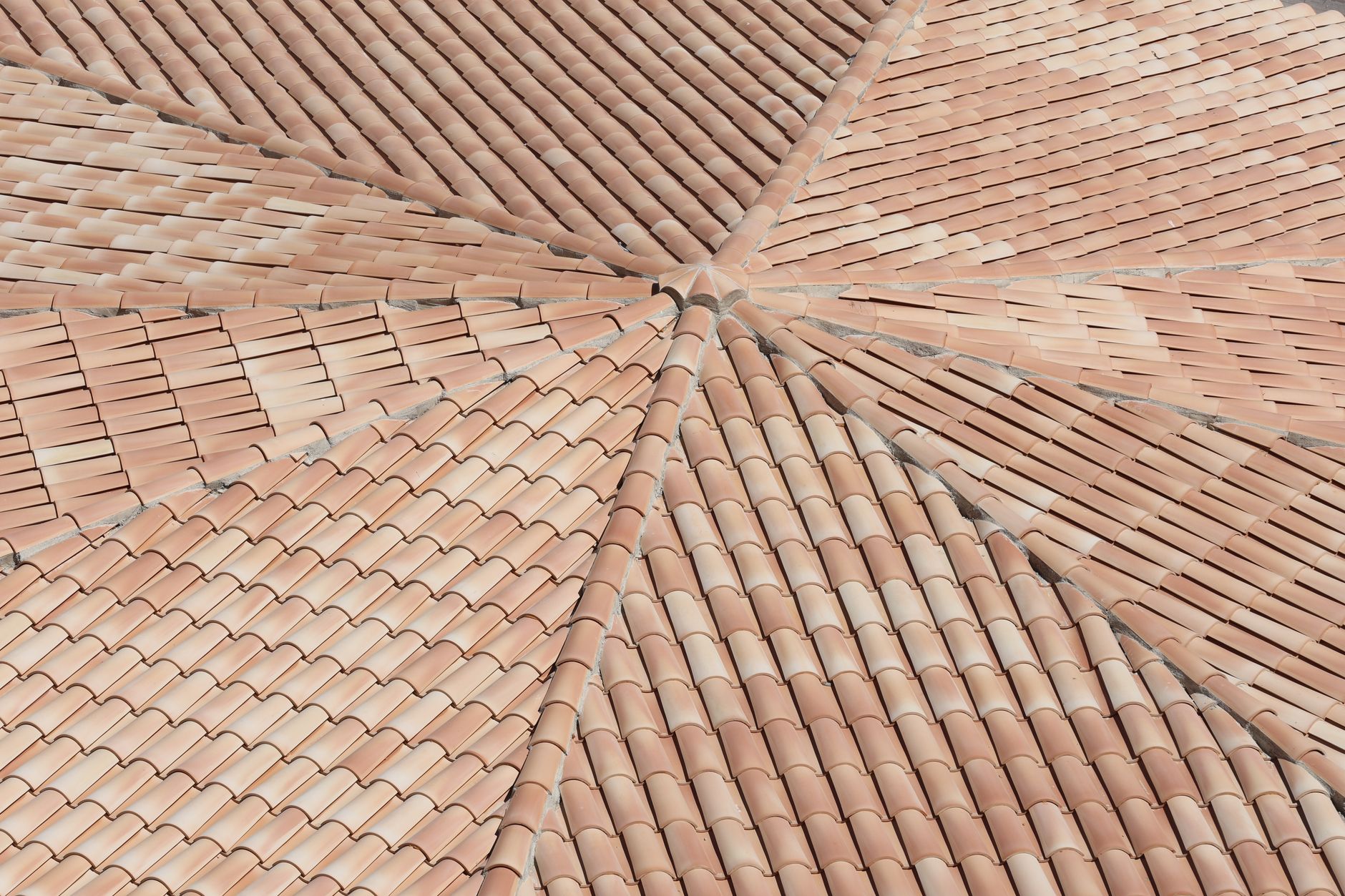 Roofer installing clay plain tiles as part of a UK roof tile materials comparison job