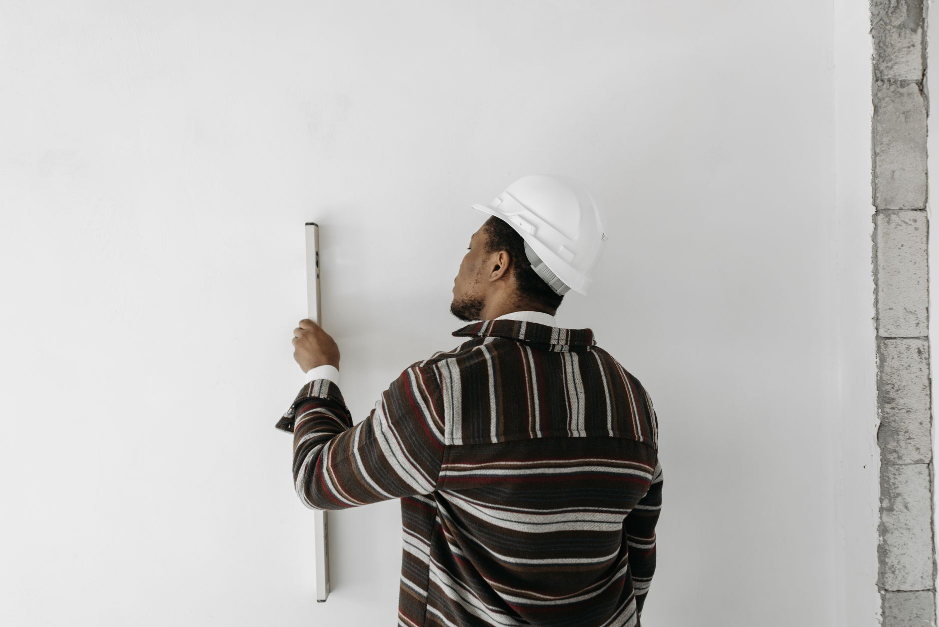 Tradesman using moisture meter to diagnose rising damp vs penetrating damp on a UK property